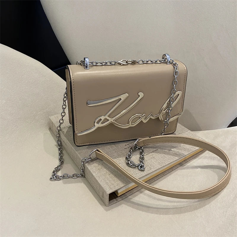 Sac à bandoulière tendance femme, couleur unie, avec logo en métal et chaîne, fermeture magnétique, idéal pour un usage quotidien